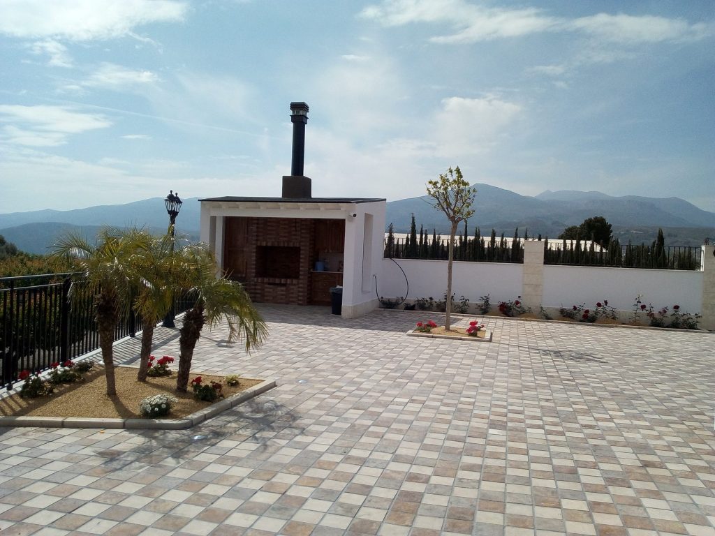 Jardín pavimentado y barbacoa de la casa de madera de Tíjola