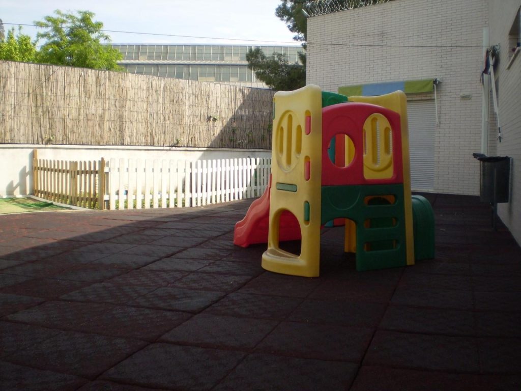 Patio exterior con pavimento de caucho de la escuela infantil de Heliópolis