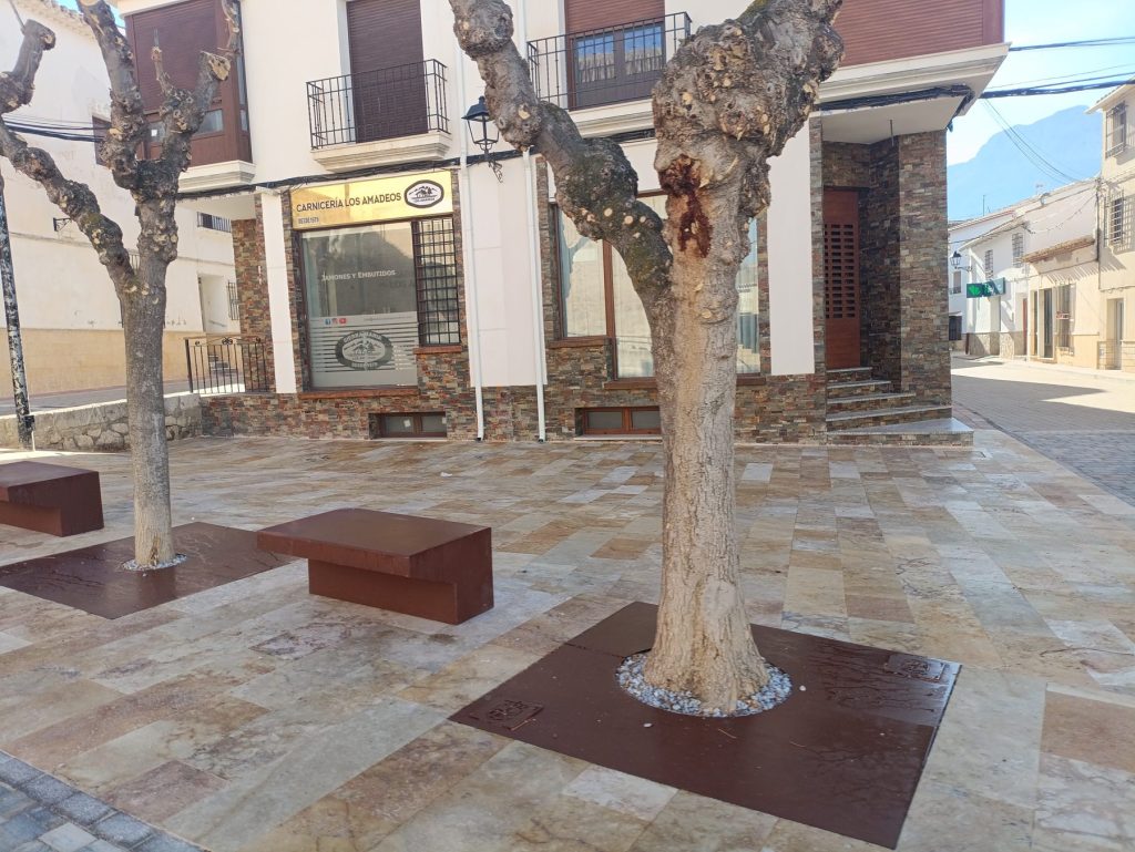 Bancos de acero corten y arbolado en la plaza peatonalizada de María